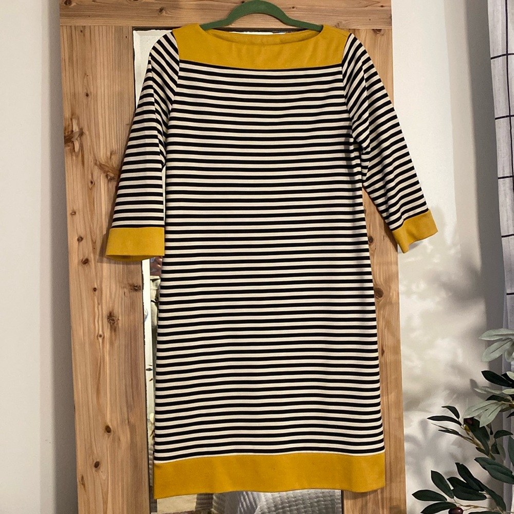 Women’s stripe dress with mustard accent.